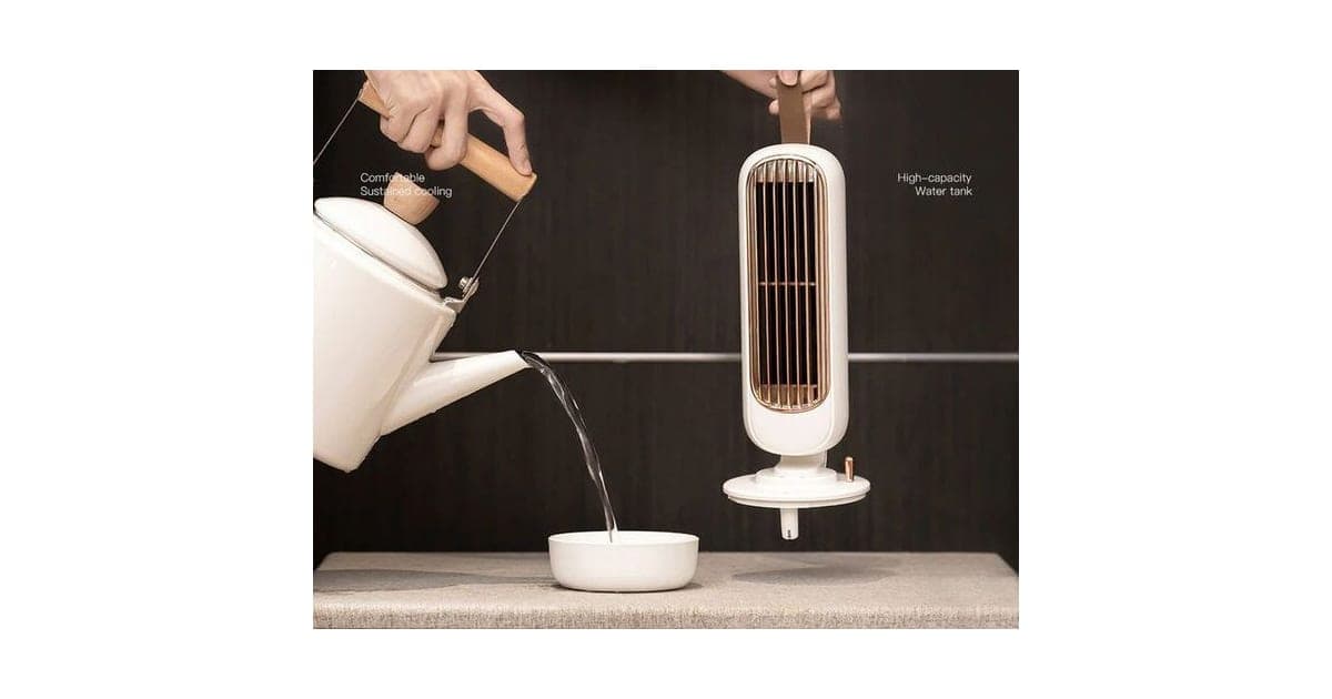 White AirCooly tower fan with a copper-coloured grille and leather strap, lifted off its base while water is poured from a kettle