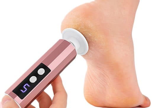 Hand holding the rose-gold CallusClear Pro with a white disc head against a dry, cracked heel