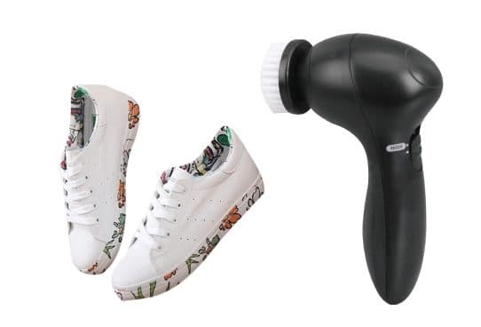 Black CleanX handheld cleaner with a round white bristle head, next to white sneakers with floral print on the sides