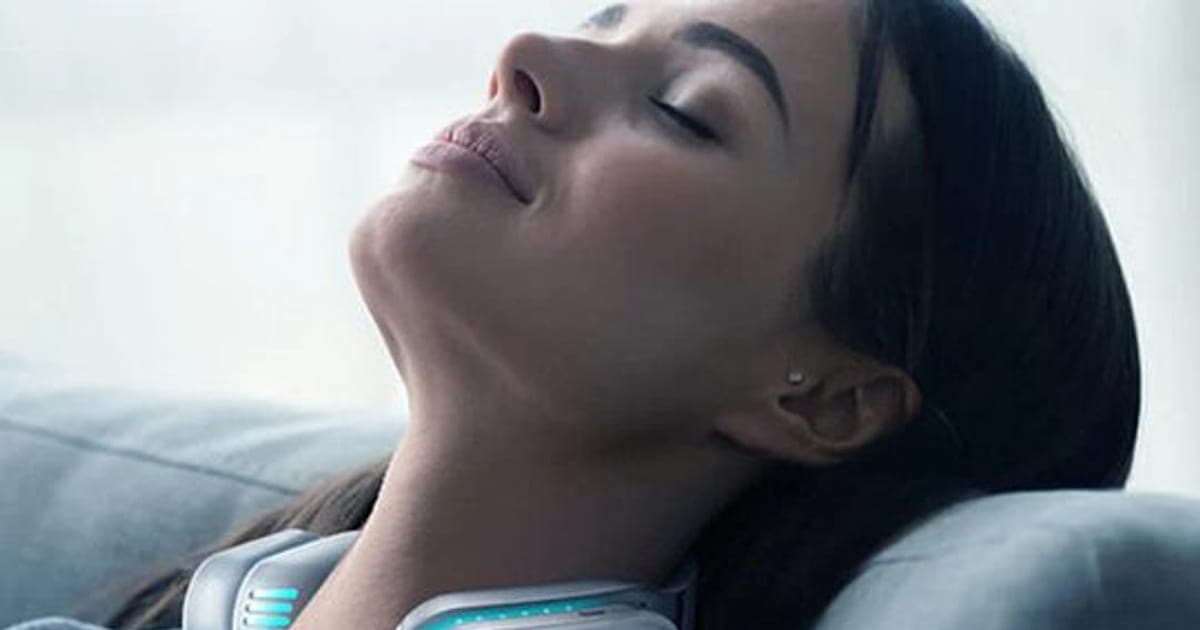 Woman relaxing on a sofa wearing a white CoolDown Pro neck device with glowing blue plates and a small display, marked HQM hot and cold machine