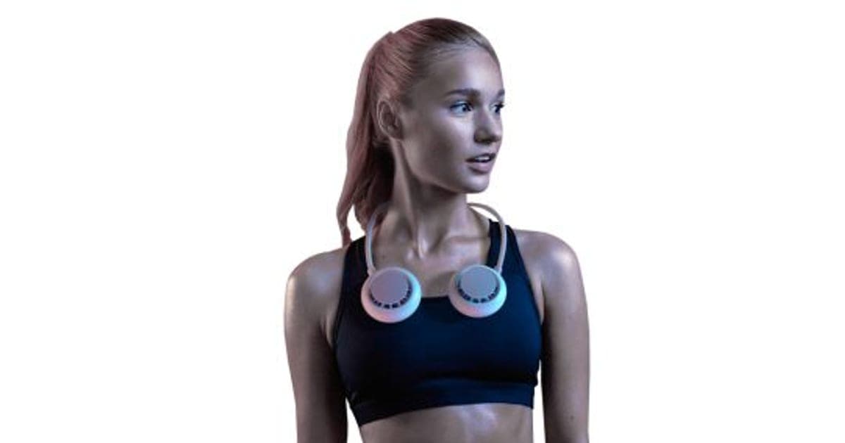 A woman in sportswear wearing the white CoolFeel Max neck fan with two round pods resting on her collarbones