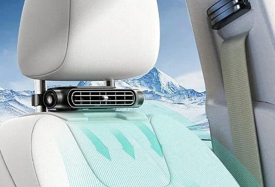 Small black CoolSeat Pro fan with a horizontal vent mounted below a car headrest, air graphics blowing onto the seat beside a seatbelt