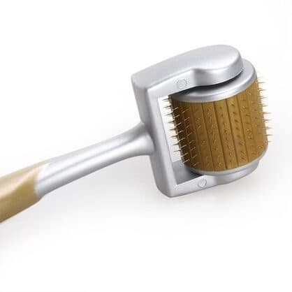 Close-up of the DXRoller's silver frame holding a gold drum lined with rows of thin titanium needles