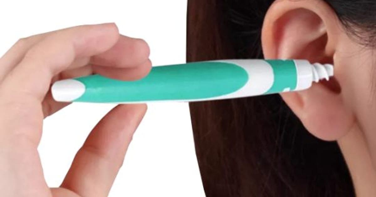 A hand holding a teal and white Easy WaxOff tool with a white spiral tip placed at a woman's ear