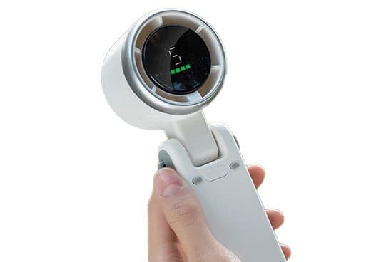 Hand holding a white EasyBreeze Mini with a hinged handle and a round fan head with a digital display