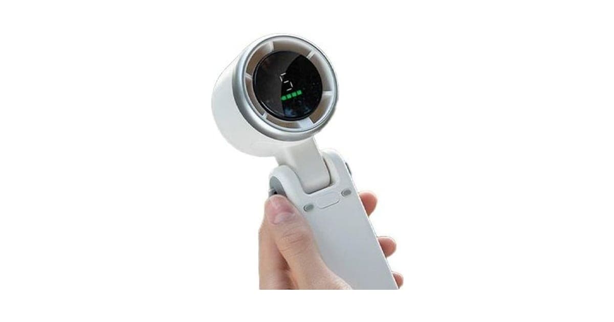 White EasyBreeze Mini handheld fan with a round head showing speed 5 and green battery bars, held in a hand with its foldable handle