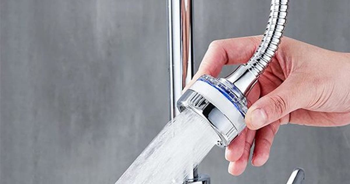 Hand bending the chrome FaucetMaster gooseneck on a kitchen tap, with an aerated spray coming from its round head with a blue filter band