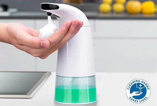 Foamatic dispenser beside a sink dispensing a dollop of white foam into an open hand