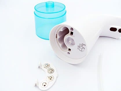 Foamatic body upside down with the blue soap tank removed and the battery contact plate beside it