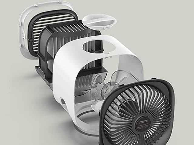 Exploded view of a white cube cooler showing the front grille, a wet filter block, the top water cap, the shell and a black rear fan