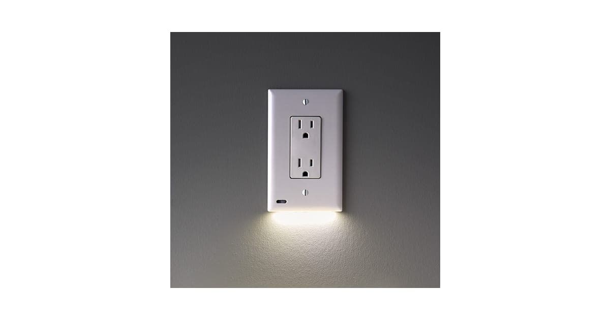 White GuideLight outlet cover on a grey wall with a soft LED glow shining down from its lower edge