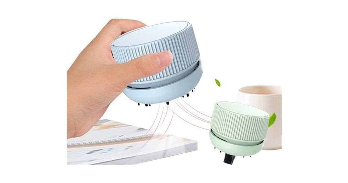 Hand gliding a pale blue HandyVacuum over a book, beside a mint green one next to a mug, with suction lines