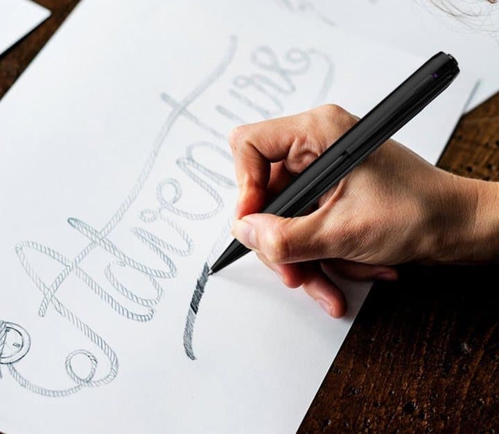 Hand writing in cursive on paper with the iSpyPen Pro X camera pen