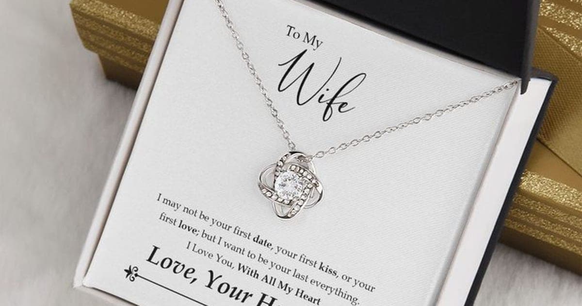 Silver-tone Love Knot Necklace with a round clear stone in a woven knot pendant, on a To My Wife card in an open black box beside a gold gift box
