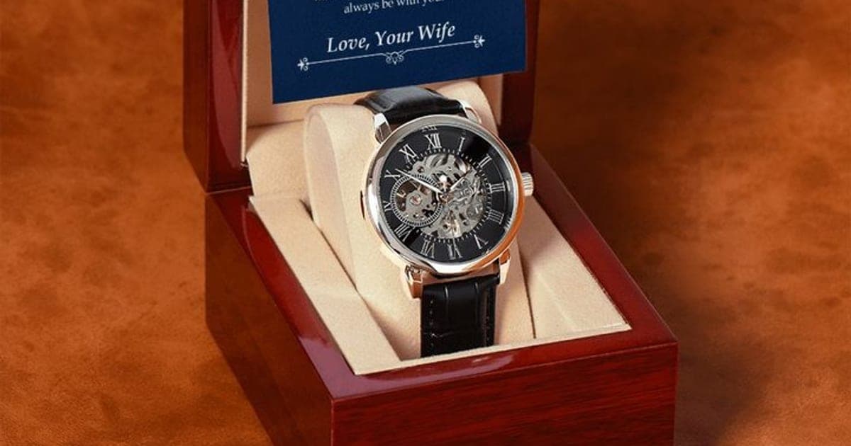 Luxury Open Watch with a rose gold-tone case, black skeleton dial showing gears and Roman numerals, on a black leather strap in an open mahogany-style box under a To My Husband card