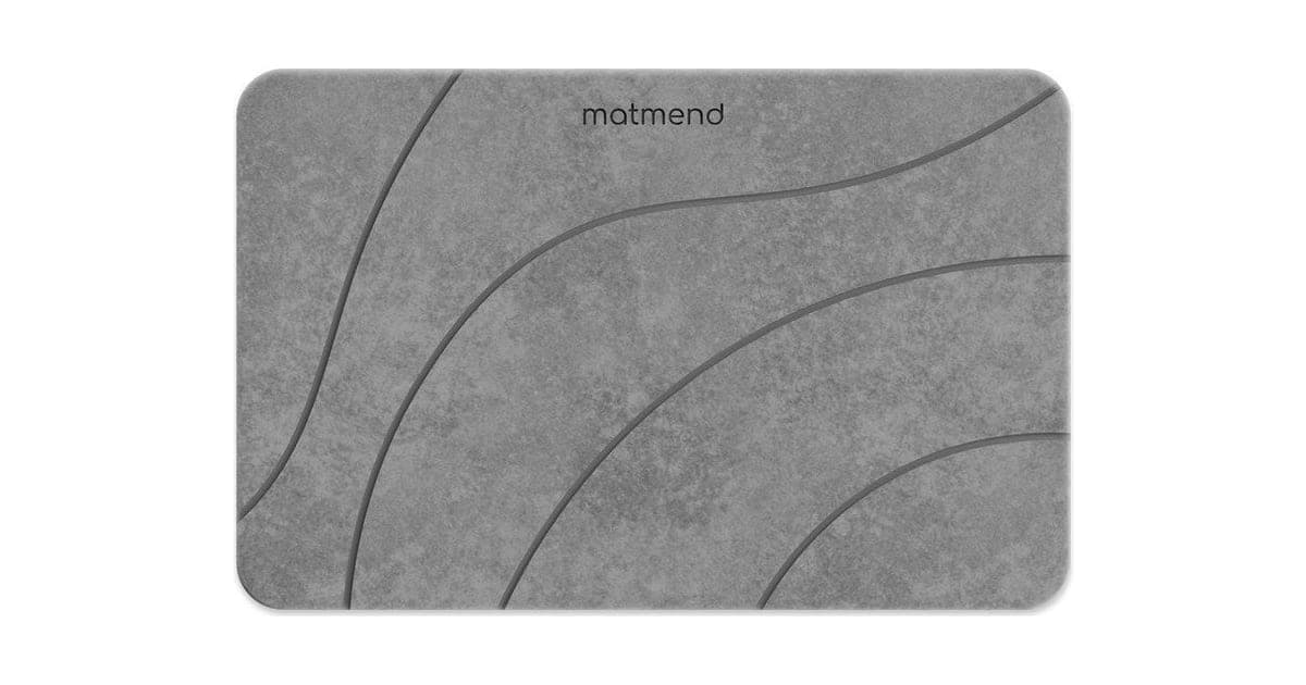 Grey MatMend stone bath mat with curved line pattern and small brand name
