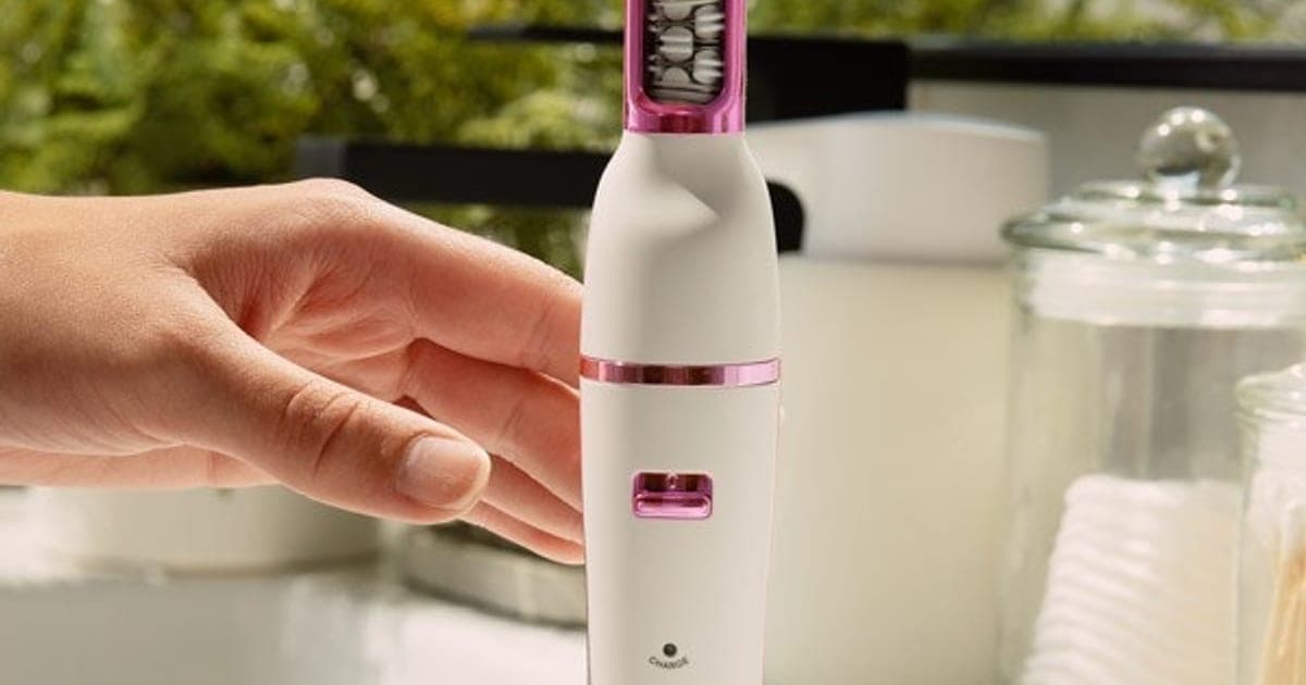 White Pluxy Epil Pro facial epilator standing on a bathroom counter with a hand reaching for it