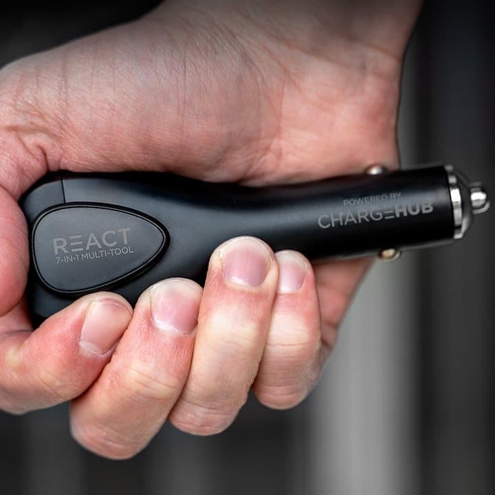 Hand holding the black React ChargeHub device to show its size