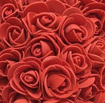 Close-up of many small red foam roses packed together, showing their curled petals