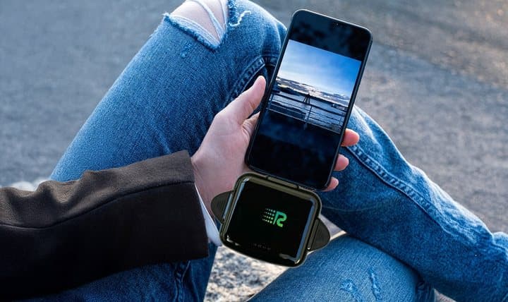 Person sitting on steps holding a phone with Rush Charge Universe plugged in