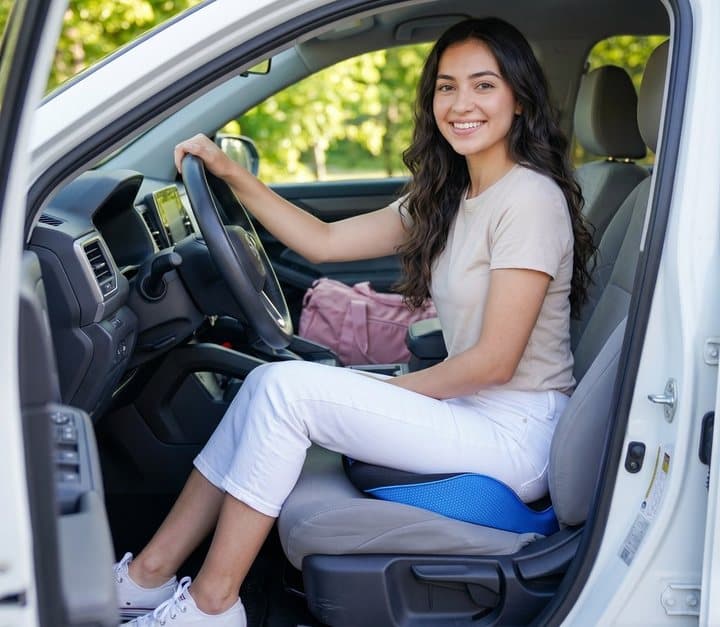 Woman driving a car while sitting on a Serenesitz cushion