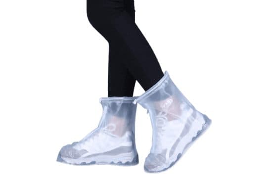 Person walking in clear ankle-high ShoesCover Max covers over white trainers, with drawstrings at the top