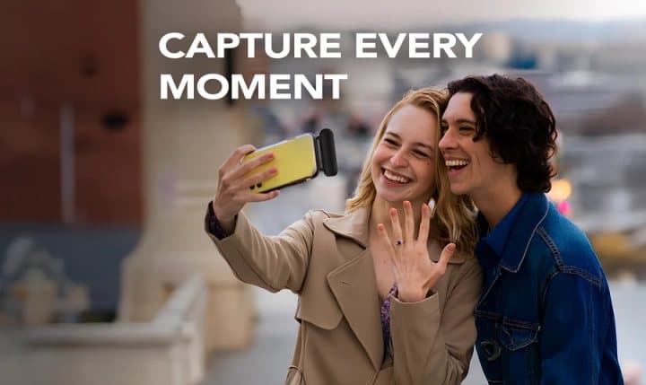 Couple taking a selfie with a phone that has Snap-N-Charge attached to the bottom