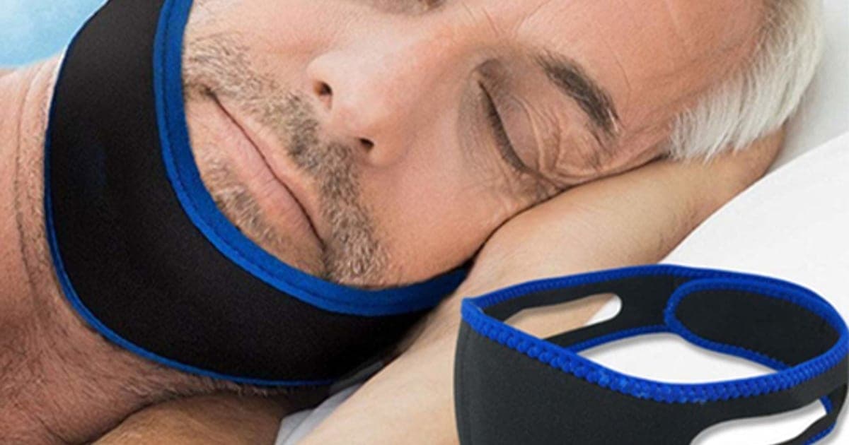 A sleeping man wearing the black and blue Snore Strap neoprene chin strap, with the strap shown beside him