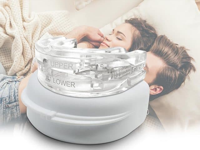 Clear SnoreCut Bite mouthguard on its round white case in front of a couple sleeping peacefully
