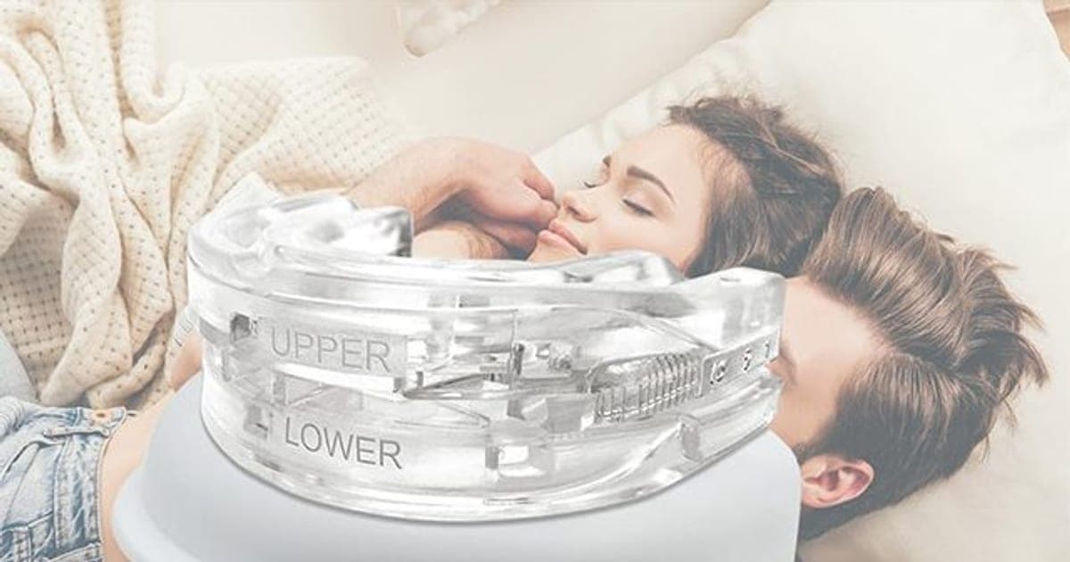 Clear SnoreCut Bite mouthguard marked upper and lower with a side gear, resting on its white case in front of a couple sleeping