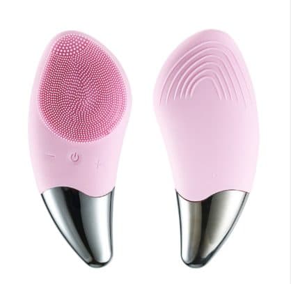 Front and back of a pale pink SootheSkin Pro, one side with fine silicone bristles and buttons, the other with curved ridges, both with chrome tips