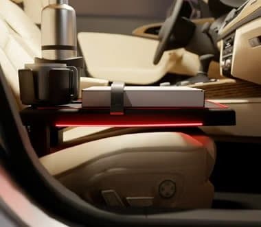 Stupid Car Tray fitted on a car's front passenger seat holding a drink and a box, lit by a red light strip