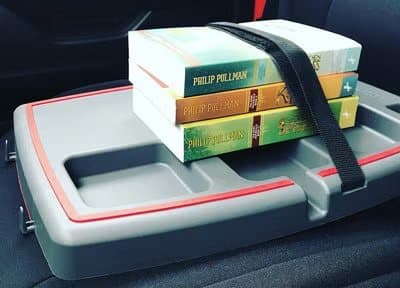 Stupid Car Tray in a car with three books strapped down by its black strap
