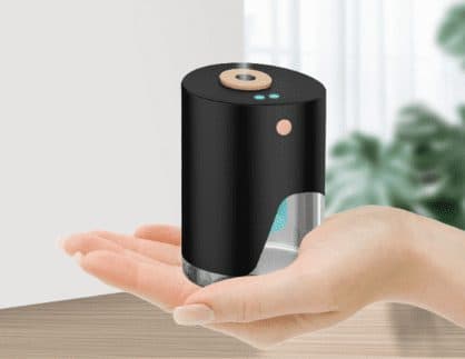 VapeSan Pro resting on an open palm by a window, with a lit window in the tank showing a blue glow