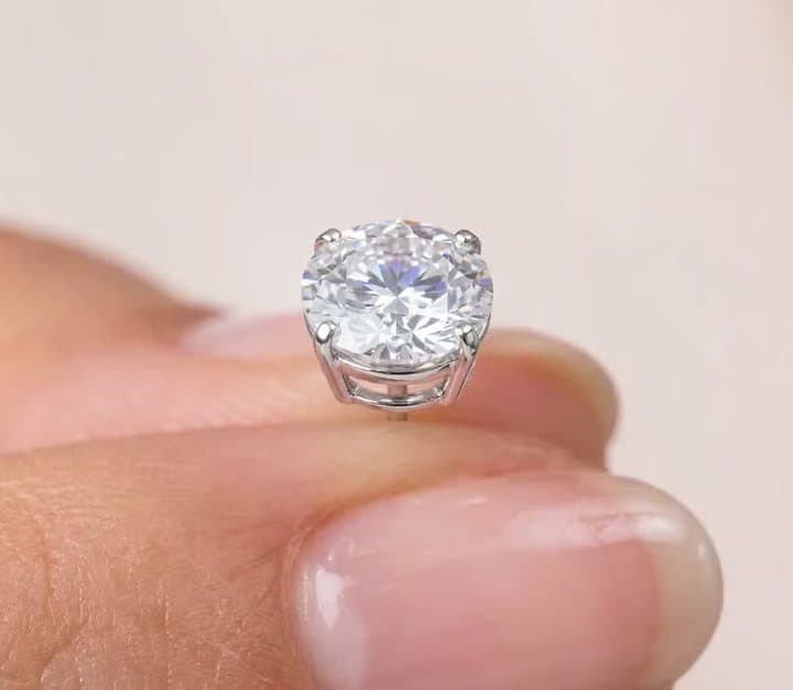 Single Voss+Agin lab-grown diamond stud held on a fingertip