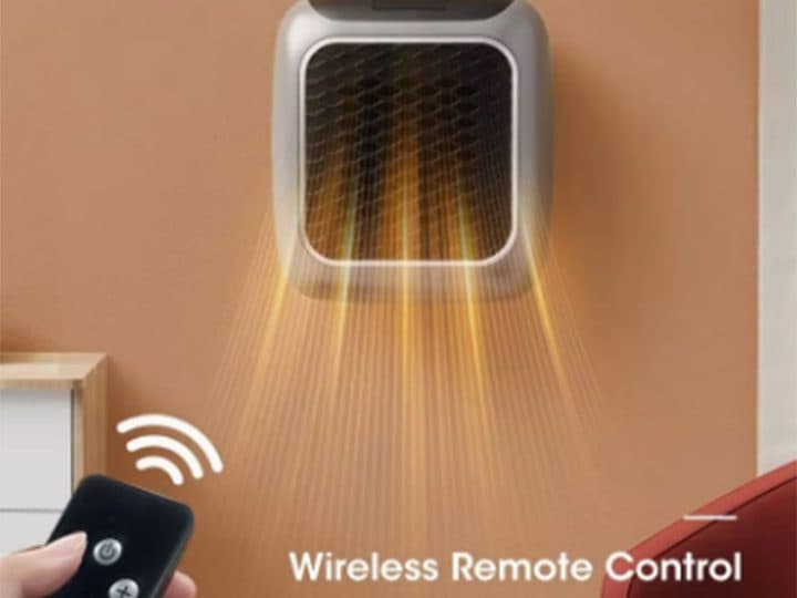 WarmAIR Pro mounted on a wall socket blowing warm air, with a hand holding a remote below, labelled wireless remote control
