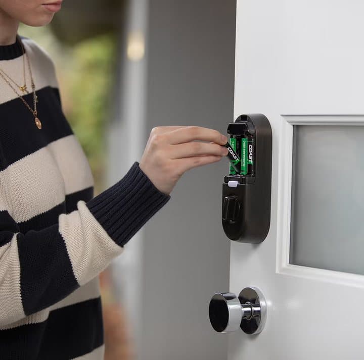 Person inserting Zithion-X batteries into a smart door lock
