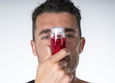 A man holding the AirPhysio to his mouth, with the device angled