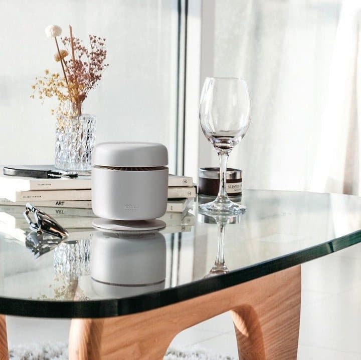 Aroma Amplifier on a glass coffee table with books, flowers and a wine glass