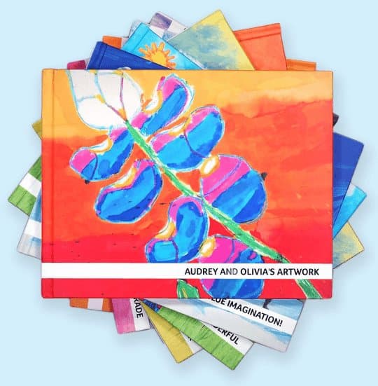 Stack of colourful Artkive hardcover books with children's paintings on the covers