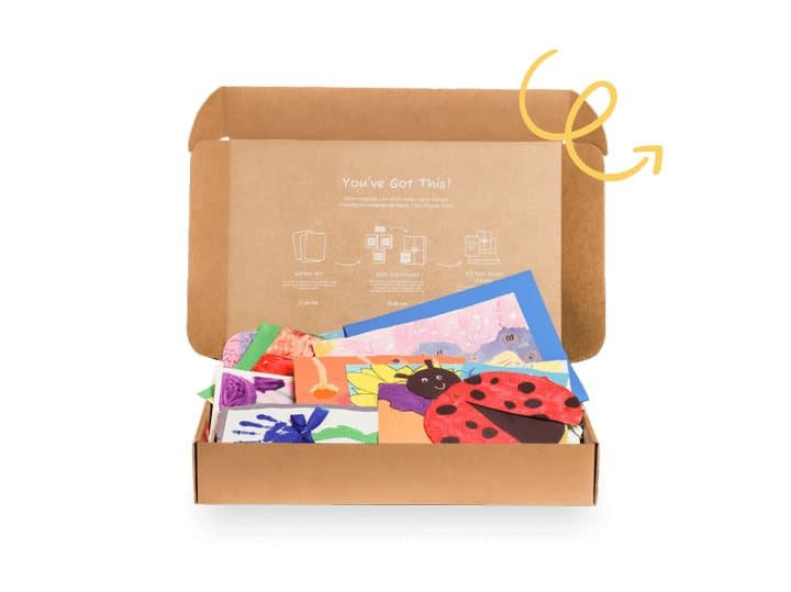 Open Artkive cardboard box filled with colourful children's paintings and a ladybird craft