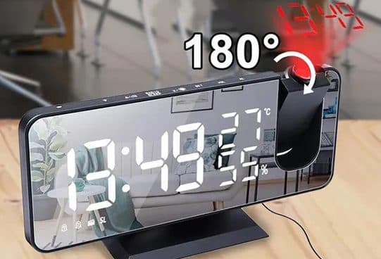 BigTime Pro mirror-face desk clock reading 13:49 with temperature and humidity, and a red projector head turned to cast the time on the wall