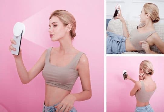 Three photos of a woman taking selfies with a round white light clipped to her phone, standing, lying on a sofa and facing a wall