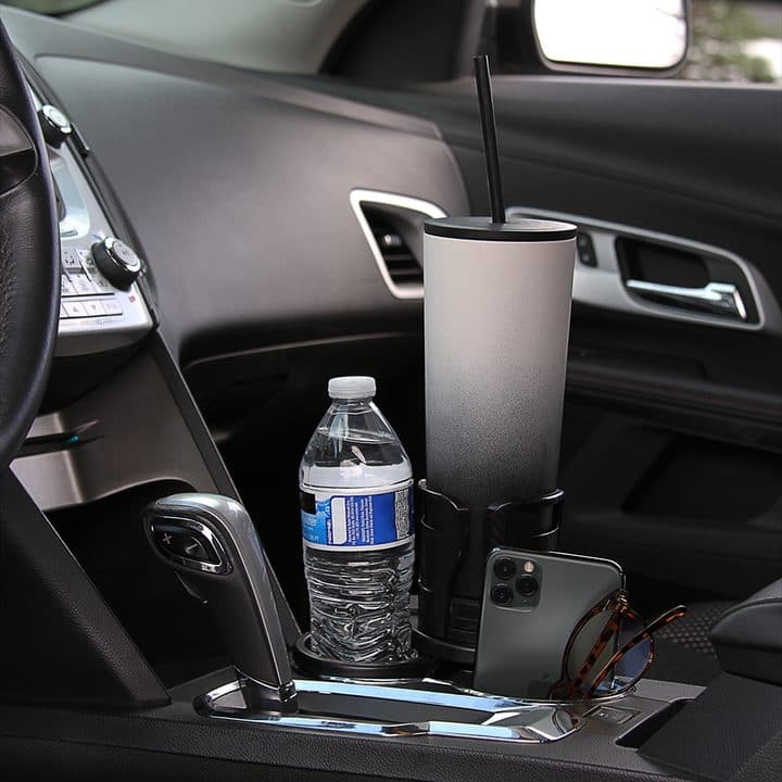 Dual CupStation holding a large tumbler with a straw beside a water bottle and phone in a car console