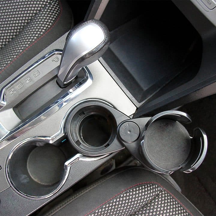 Dual CupStation swivelled beside a car's original cup holders next to the gear selector