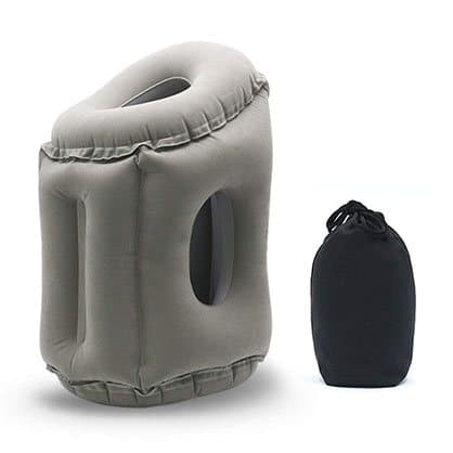 Inflated grey ErgoRelax pillow with side holes next to a small black drawstring travel bag