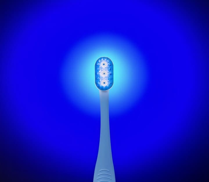 Great Gums toothbrush head glowing blue to show the bioelectric chip is active