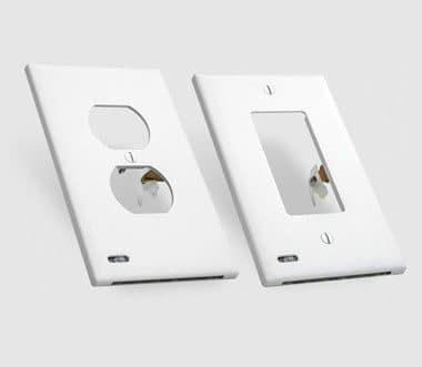 Two white GuideLight cover plates showing the duplex and Décor openings and the light sensor