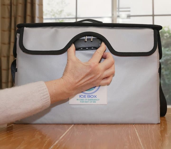 Hand setting the combination lock on the front of the grey ICE Box document case
