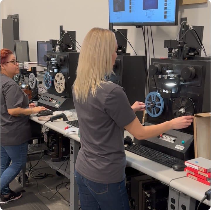 iMemories technicians operating film projectors and digitizing equipment in a lab